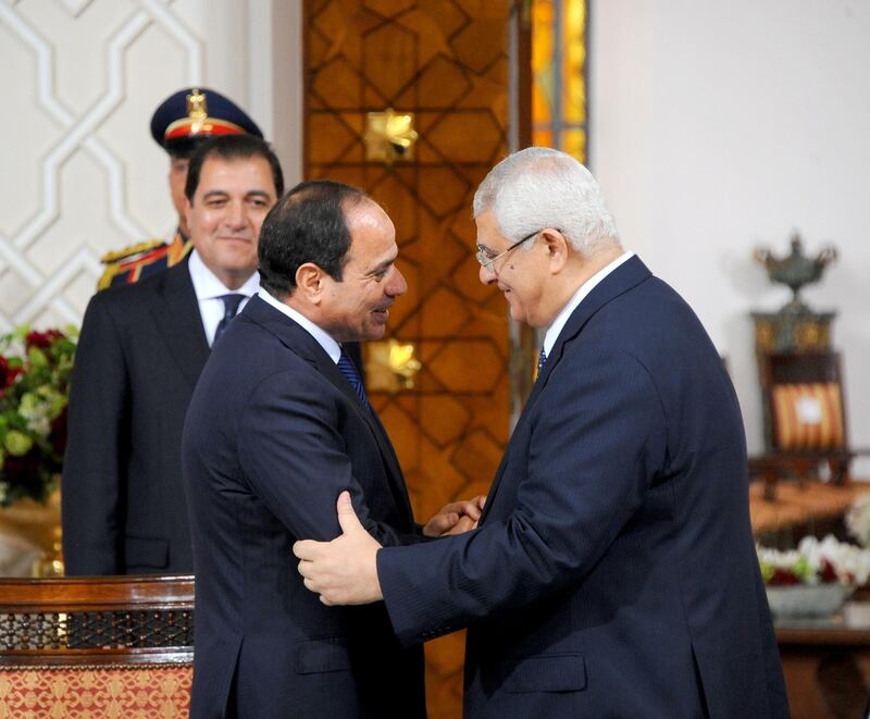 A handout picture made available on June 8, 2014 by the Egyptian presidency shows former army chief Abdel Fattah al-Sisi (L) shaking hands with outgoing interim president Adly Mansour (R) after signing the handing over of power document in Cairo. Sisi was sworn in as Egypt's president, formalising his de facto rule since he deposed the elected Islamist last year and crushed his supporters.  AFP PHOTO / HO / EGYPTIAN PRESIDENCY == RESTRICTED TO EDITORIAL USE - MANDATORY CREDIT "AFP PHOTO / EGYPTIAN PRESIDENCY" - NO MARKETING NO ADVERTISING CAMPAIGNS - DISTRIBUTED AS A SERVICE TO CLIENTS == (Photo by - / EGYPTIAN PRESIDENCY / AFP)