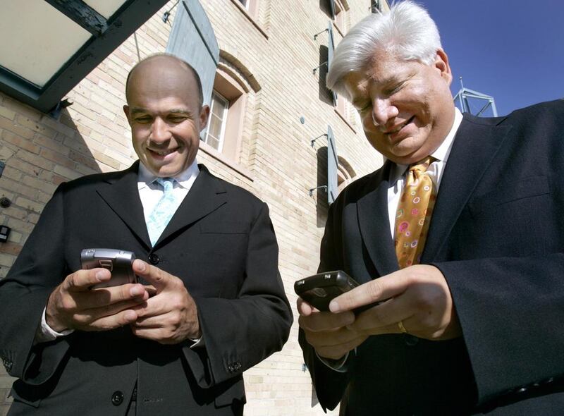 In this 2006 photo, Jim Balsillie, left, then the RIM co-chief executive, and Mike Lazaridis, the company’s founder use their BlackBerry devices. JP Moczulski / Reuters