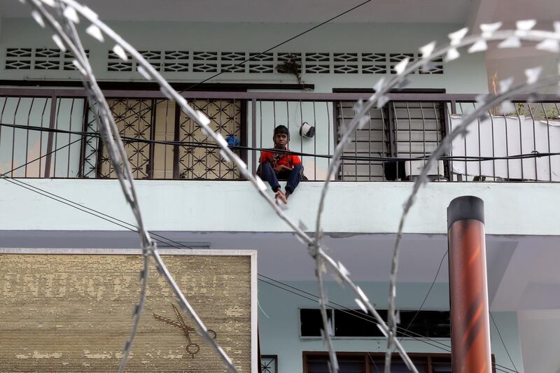 A boy looks out from his home under enhanced lockdown, during the movement control order due to the outbreak of the coronavirus disease (COVID-19), in Selayang, Malaysia. REUTERS