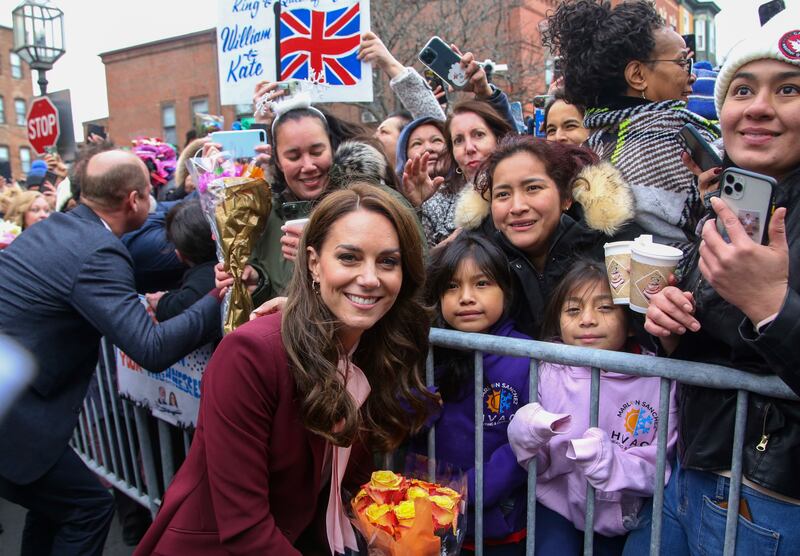 The Princess of Wales poses for a photo with the crowd after a tour of Roca in Chelsea, Massachusetts. Prince William greets people on the left. AP