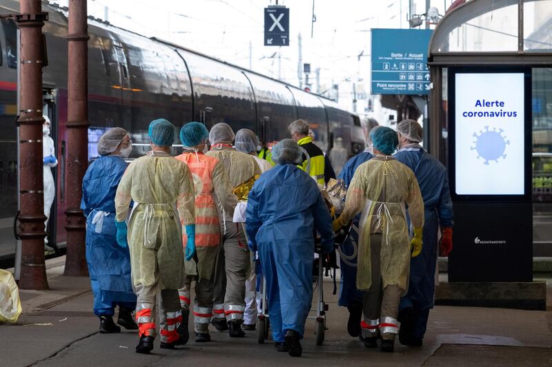 Medical staff carry a patient infected with the Covid-19 onboard a medicalized TGV high speed train at the railway station in Strasbourg. Pool via Reuters