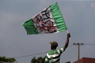 epa08763203 A protester holds a stained Nigerian flag along a road during a protest against the Nigeria rogue police, otherwise know as Special Anti-Robbery Squad (SARS), in Lagos, Nigeria, 21 October 2020. It has been two weeks since a protest against SARS began and Protesters say agitation against police brutality continues as an entry point to addressing other social and political issues such as corruption, official ineptitude to public accountability, and government inefficiency in Nigeria. Protesters defiled a 24-hour curfew earlier imposed on the Lagos metropolitan city by the governor to continue the protest after a military attack on the protesters at a toll gate in Lagos on 20 October 2020. EPA/AKINTUNDE AKINLEYE