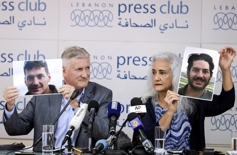 Marc (L) and Debra Tice, parents of US journalist Austin Tice who was kidnapped in Syria five years prior, hold respective dated portraits of him during a press conference in the Lebanese capital Beirut on July 20, 2017. (Photo by JOSEPH EID / AFP)