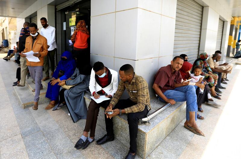 People wait outside currency exchange bureau in Khartoum, Sudan February 28, 2021. REUTERS/Mohamed Nureldin Abdallah