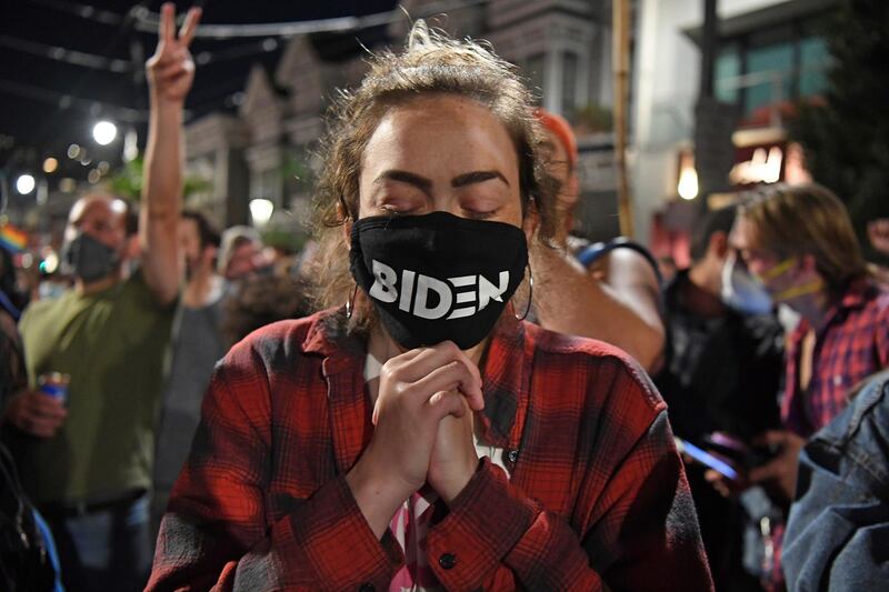 With tears in her eyes, Alyssa Oemlenart, of San Francisco, listens in San Francisco to a broadcast of President-elect Joe Biden as he speaks after winning the presidential election, November 7, 2020. AP