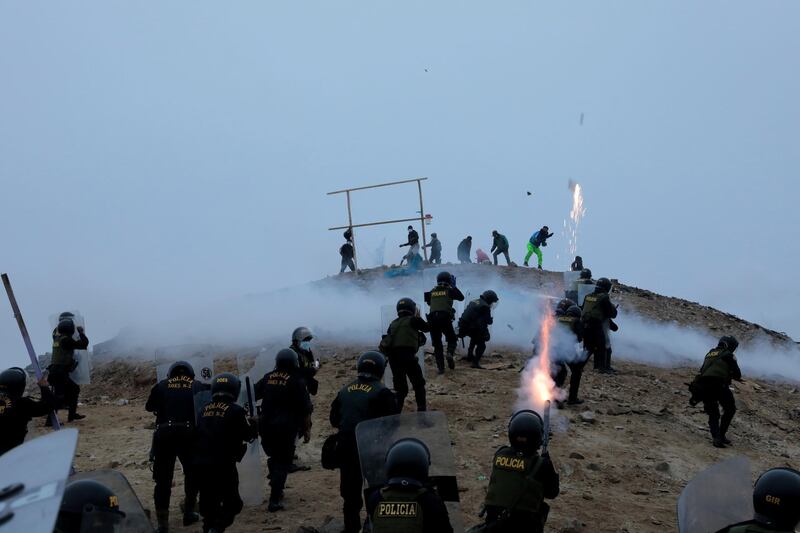 Riot police clash with people occupying the land on the Morro Solar during an eviction following a coronavirus outbreak in Chorrillos, Peru. Reuters