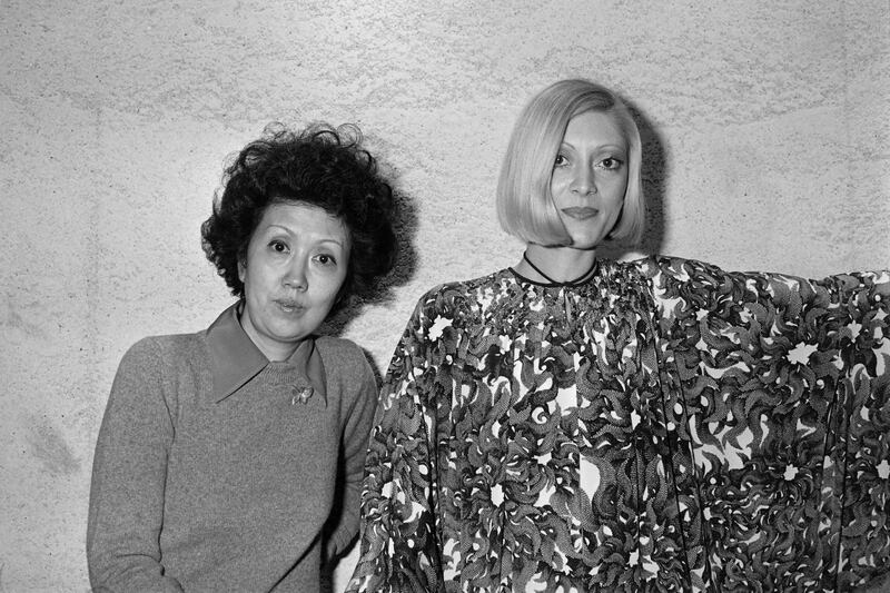 (FILES) This file picture taken on January 26, 1977 shows Japanese fashion designer Hanae Mori (L) with a fashion model wearing clothing from her creations in Paris.  - Japanese fashion designer Hanae Mori, who cracked the elite world of Parisian haute couture, has died at her home in Tokyo aged 96, Japanese media reported on August 18, 2022.  (Photo by AFP)