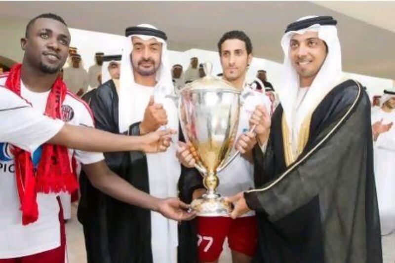 Sheikh Mohamed bin Zayed presents Al Jazira captain Saleh Obaid, second right, the President's Cup at Zayed Sports City. 