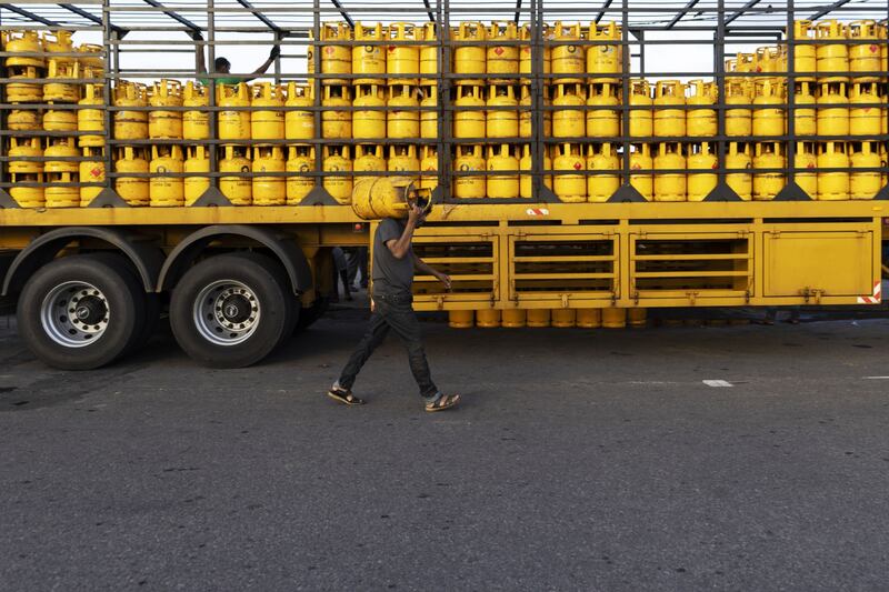 A man carries a cooking gas cylinder in Galle, Sri Lanka. The country has decided to limit distribution of fuel to essential services until July 10. Bloomberg