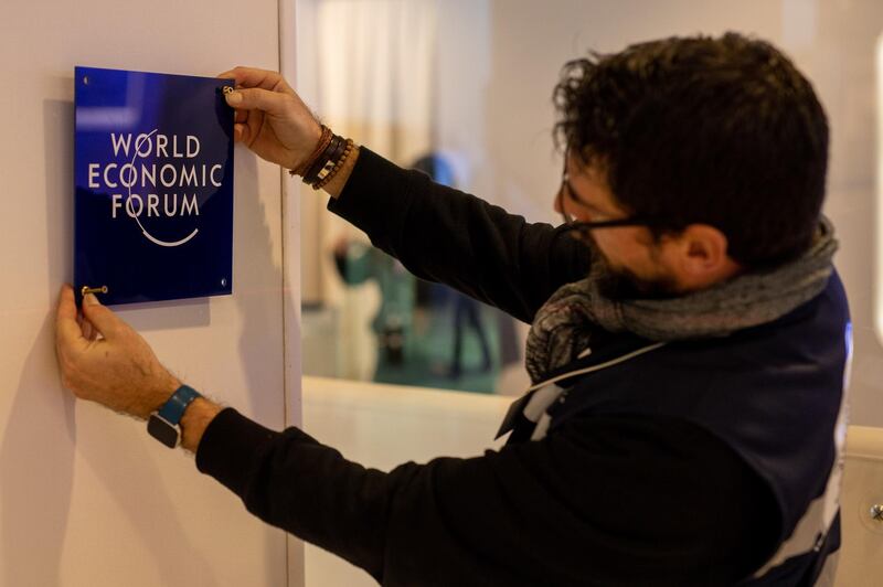 A worker hangs a sign inside the Congress Centre ahead of the World Economic Forum in Davos, Switzerland. Bloomberg