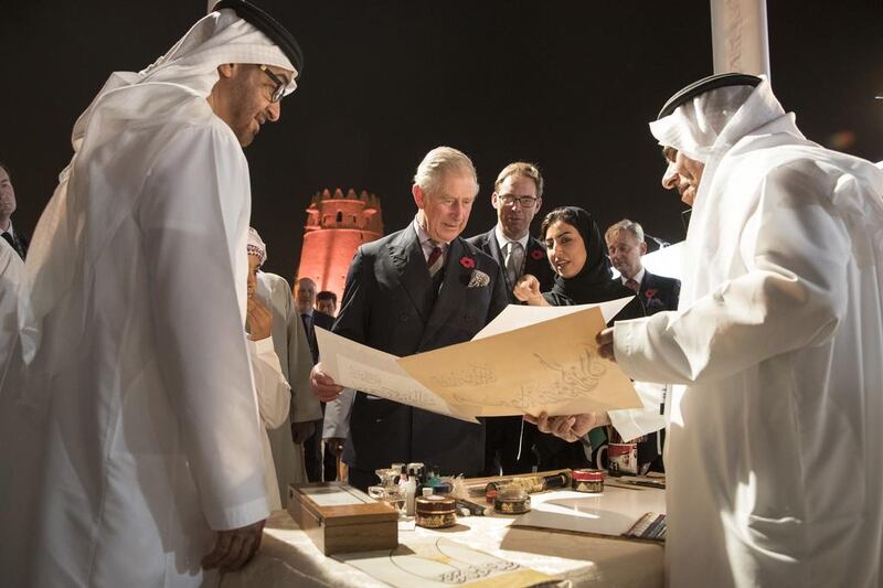 Sheikh Mohammed bin Zayed, Crown Prince of Abu Dhabi and Deputy Supreme Commander of the Armed Forces, watches as calligrapher Mohamed Mandi writes Prince Charles’s name at the launch of the UK-UAE Year of Cultural Collaboration at Al Jahili Fort in Al Ain. Ryan Carter / Crown Prince Court - Abu Dhabi