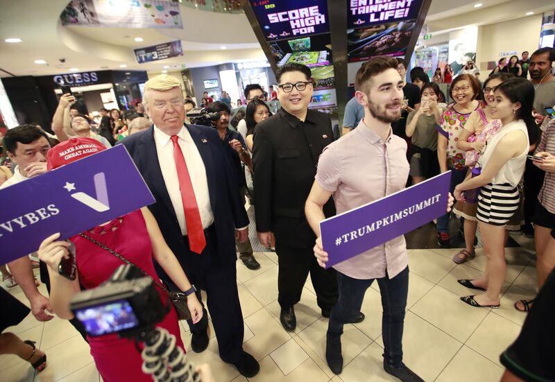 epa06795683 Kim Jong-un impersonator Howard X (R) and Donald Trump impersonator Dennis Alan (L) walk past shoppers as they make an appearance at the Bugis Junction shopping mall in Singapore, 09 June 2018. US President Donald J. Trump and North Korean leader Kim Jong-un are scheduled to meet at the Capella Hotel on Singapore's Sentosa Island for an historic summit on 12 June 2018.  EPA/HOW HWEE YOUNG
