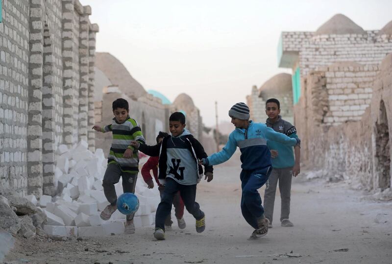 Children play football at the graveyards. Reuters