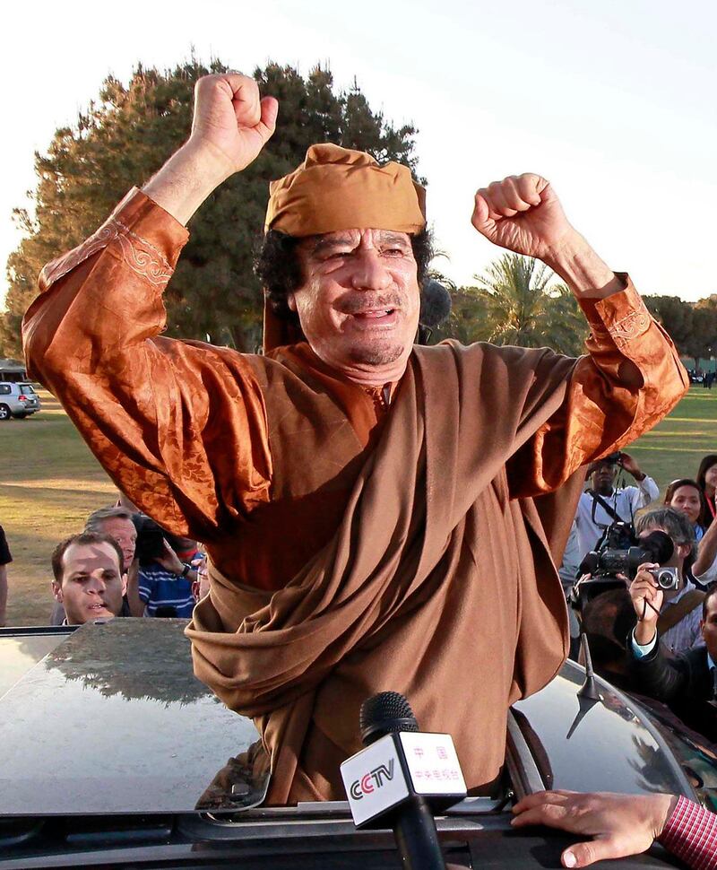 Libyan leader Muammar Gaddafi gestures from a car in Tripoli, after a meeting with a delegation of five African leaders seeking to mediate in Libya's conflict in this April 10, 2011 file photo. Deposed Libyan leader Gaddafi was captured and wounded near his hometown of Sirte at dawn on October 20, 2011 as he tried to flee in a convoy which NATO warplanes attacked, National Transitional Council official Abdel Majid said on Thursday.  REUTERS/Louafi Larbi/Files (LIBYA - Tags: POLITICS CIVIL UNREST) *** Local Caption ***  SIN27_LIBYA-_1020_11.JPG