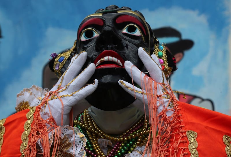 Luis Chacon, the current person representing Mama Negra, adjusts his mask during the festival in honor of the Virgin of Las Mercedes in Latacunga, Ecuador. AP Photo