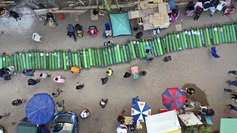 NEW Dozens of empty oxygen cylinders lay across a dirt road, as people wait for a shop to open in order to refill their tanks in the Villa El Salvador neighborhood, as the lack of medical oxygen to treat COVID-19 patients continues in Lima, Peru, Tuesday, April 6, 2021.  (AP Photo/Rodrigo Abd)