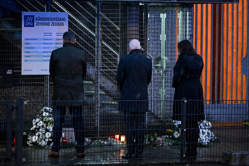 Mr Tschentscher, centre, Mr Grote, left, and Ms Fegebank pay their respects at the scene of the shooting. AFP