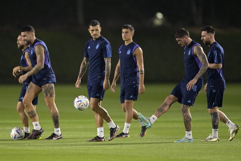 Rodrigo De Paul kicks a ball next to Lionel Messi, Alejandro Gomez, Nicolas Otamendi, Leandro Paredes and Paulo Dybala during a training session at Qatar University. AFP