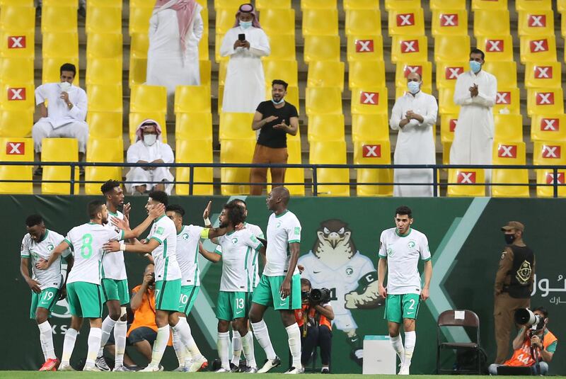 Yasser Al-Shahrani celebrates with teammates after scoring Saudi Arabia's first goal against Palestine as fans cheer from the stands. Reuters