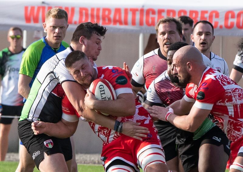 Rory Smith of Dubai Tigers attempts to resist a tackle from the Abu Dhabi Harlequins.