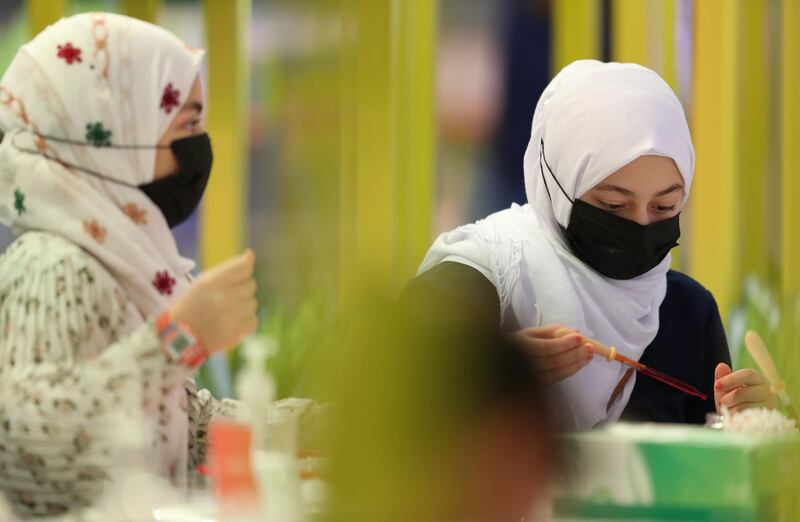 Schoolchildren wearing face masks take part in a workshop. EPA