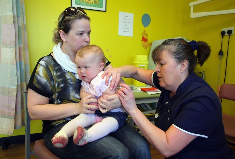 (FILES) In this file photo taken on April 20, 2013 14-month-old Amelia Down sits on the lap of her mother Helen (L) as she receives the combined Measles Mumps and Rubella (MMR) vaccination at an MMR drop-in clinic at Neath Port Talbot Hospital near Swansea in south Wales on April 20, 2013.  Measles cases are skyrocketing in Europe and the disease is surging in four countries previously considered to have eliminated it, including Britain, the World Health Organization (WHO) warned on August 29, 2019, urging countries to step up vaccination efforts. / AFP / GEOFF CADDICK
