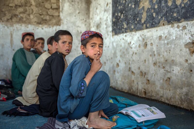 Students sit in their classroom at Assad Suri Primary School in Kandahar's Zhari District. Many of the buildings have been destroyed in airstrikes and by blasts, leaving classrooms exposed and bullet riddled. Part of the school continues to be occupied by the local police. 