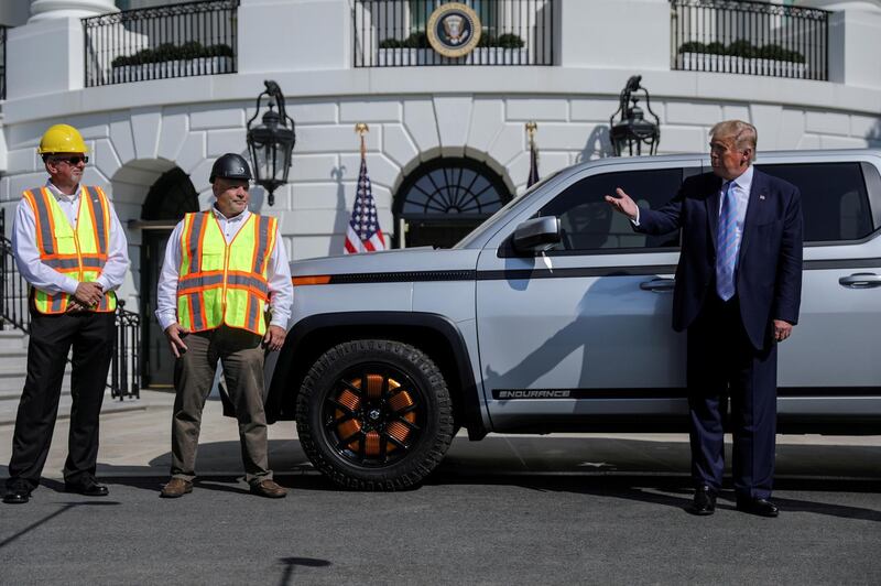 FILE PHOTO: Former U.S. President Donald Trump speaks next to two Lordstown Motors employees while inspecting the Lordstown Motors 2021 Endurance truck, an electric pickup truck, on the South Lawn at the White House in Washington, U.S., September 28, 2020. REUTERS/Carlos Barria/File Photo