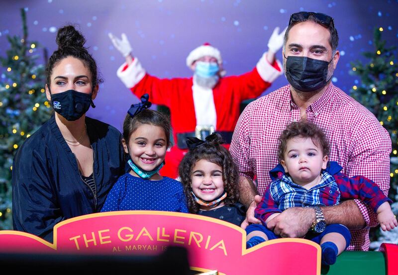 Abu Dhabi, United Arab Emirates, December 9, 2020.  The Nachar family pose with socially distanced Santa at the Winter Village, The Galleria Al Maryah Island.
Victor Besa/The National
Section:  NA
For:  Stock/Standalone