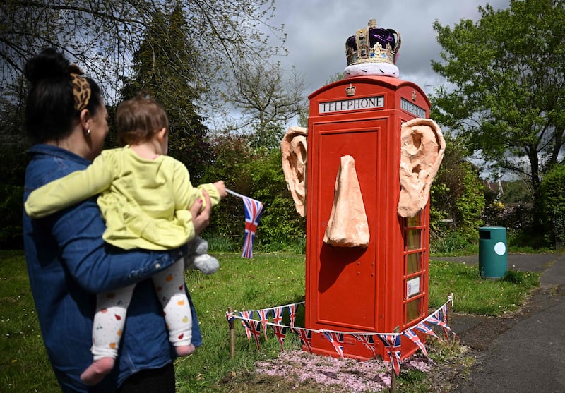 A telephone box in the village of Compton, Surrey, decorated with the ears, nose and crown of King Charles. AFP