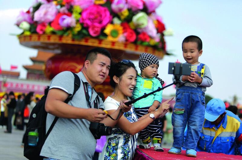 A family takes a selfie in front of a giant basket of flowers on display at Tiananmen Square for the 65th National Day celebrations in Beijing, China on September 29, 2014. The country ended its one-child policy in 2015 and said it would give official status to about 13 millon children born illegally under the system. Jason Lee / Reuters