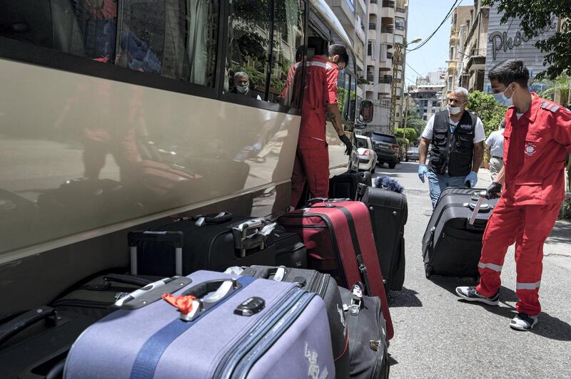 Staff of the NGO Caritas Lebanon load the women’s luggage. Finbar Anderson for The National