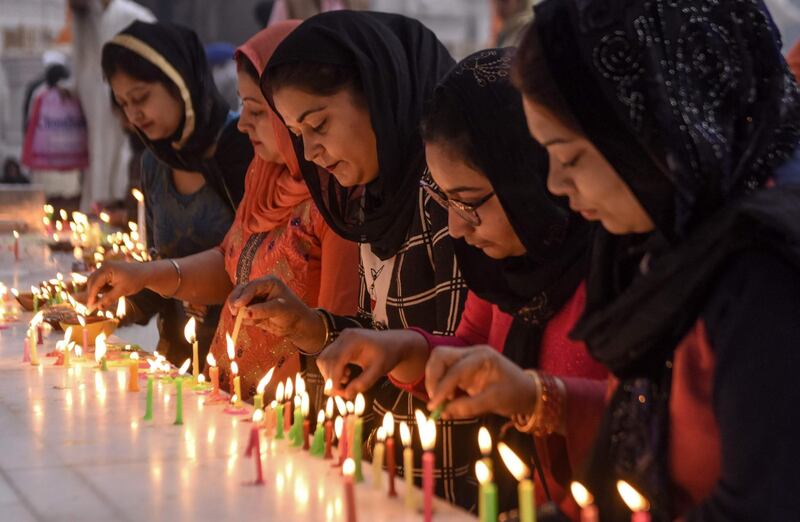 Sikh devotees light candles to pay respect on the occasion of Bandi Chhor Divas, a Sikh festival coinciding with Diwali, the Hindu festival of light, at the Golden Temple in Amritsar on November 14, 2020. / AFP / NARINDER NANU
