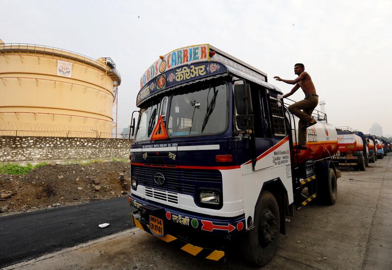 A man climbs an an oil tanker parked outside a fuel depot in Mumbai, India, October 6, 2017. REUTERS/ Danish Siddiqui
