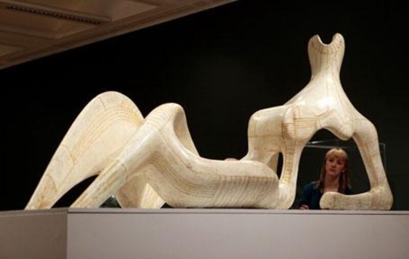 A woman admires Henry Moore's Reclining Figure 1951 on display at the Tate Britain.