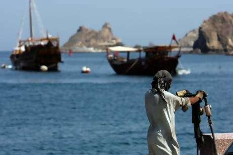 A construction worker maintaining the street near Sultan Qaboos Port in Muscat Oct 28, 2007.REUTERS/Ahmed Jadallah  (OMAN)