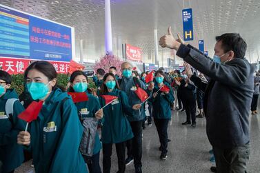 Local volunteers gesture as medical staff members, in green, from Peking Union Medical College Hospital leave at Tianhe airport in Wuhan. AFP
