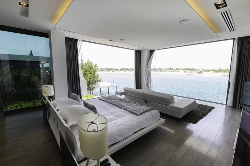 The open-plan, four-bedroom villa is perched on the edge of the bay. Christopher Pike / The National