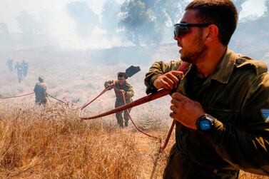 Israeli soldiers battle a blaze in a field close to the southern Israeli kibbutz of Nir Am near the border with the Gaza Strip after it was reportedly set off by incendiary kites flown from the Palestinian enclave. AFP 