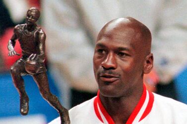 FILE - In this May 19, 1998, file photo, Chicago Bulls' Michael Jordan looks at the MVP award presented to him before the Bulls-Indiana Pacers playoff game in Chicago. Jordan described his final NBA championship season with the Chicago Bulls as a “trying year.” “We were all trying to enjoy that year knowing it was coming to an end,” Jordan told Good Morning America on Thursday, April 16, 2020. Jordan appeared on the show via video conference from his home in Florida to promote the “The Last Dance,” a 10-part documentary series focused on the final year of the 90′s Bulls dynasty that won six NBA titles in eight years. (AP Photo/Frank Polich, File)