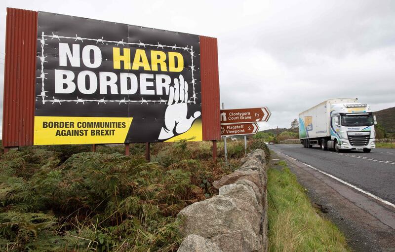 (FILES) In this file photo taken on October 01, 2019 A lorry passes an anti-Brexit pro-Irish unity billboard reading "No Hard Border", pictured from the Dublin road in Newry, Northern Ireland, on the border between Newry in Northern Ireland and Dundalk in the Irish Republic.  The British government said on September 7, 2020, that it was taking steps to "clarify" how Northern Ireland's trade will be handled after Brexit, but insisted it remained committed to its EU withdrawal agreement and the province's peace process. Britain cannot allow the peace process or its internal market "to inadvertently be compromised by unintended consequences" of the Brexit protocol relating to Northern Ireland, Prime Minister Boris Johnson's official spokesman said.
 / AFP / PAUL FAITH

