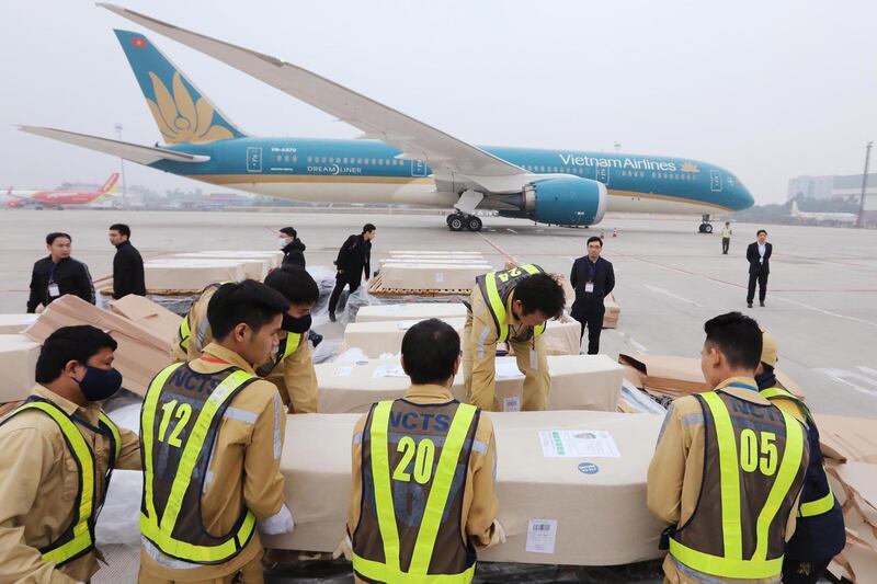 Officials move coffins containing the bodies the victims found dead in a refrigerated lorry in Britain, at the Noi Bai International Airport in Hanoi, Vietnam.  EPA