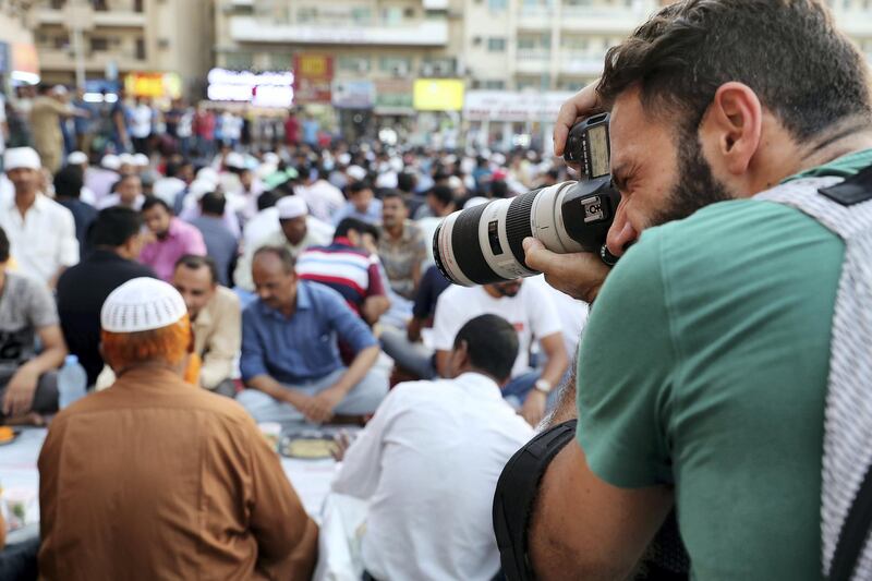 DUBAI , UNITED ARAB EMIRATES , MAY 23 – 2018 :- One of the participant taking photos during the iftar at the mosque near Al Ghubaiba bus station during the Unseen Trails Iftar Walk presented by Gulf Photo Plus and Frying Pan Adventures in Bur Dubai area in Dubai.  ( Pawan Singh / The National )  For Weekender