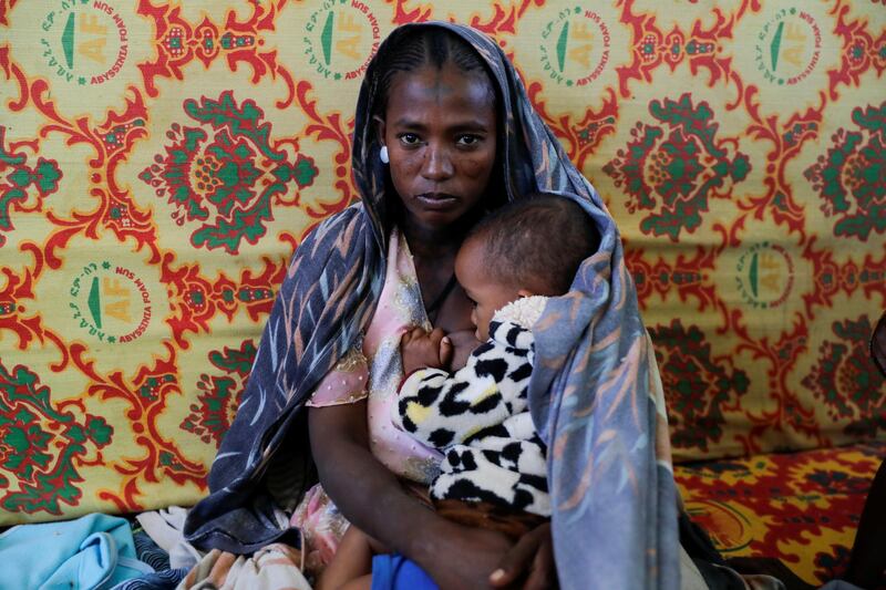 A woman holds an infant inside the Adiha secondary school, which was turned into a temporary shelter for people displaced by conflict, in the city of Mekelle, Tigray region, Ethiopia, March 12, 2021. REUTERS/Baz Ratner     SEARCH "RATNER TIGRAY" FOR THIS STORY. SEARCH "WIDER IMAGE" FOR ALL STORIES