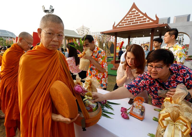 Thais offer food to Buddhist monks during the morning alms at Sanam Luang Royal Ground in Bangkok, Thailand, as a religious merit-making rite to mark the Thai traditional New Year known as 'Songkran'. EPA