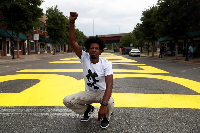 Ricco Wright poses for a photo on a street painted with a 'Black Lives Matter' message to mark Juneteenth. Reuters