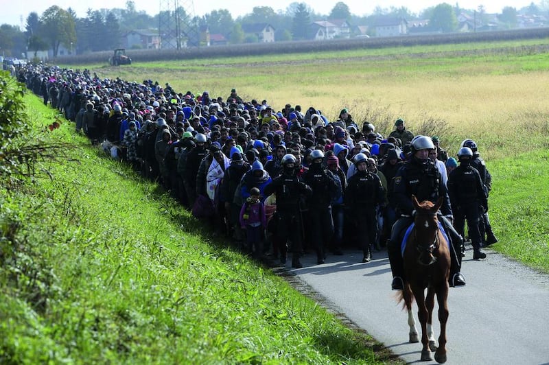 Slovenian police on foot and horseback lead a group of Syrian migrants. Srdjan Zivulovic / Reuters / October 20, 2015