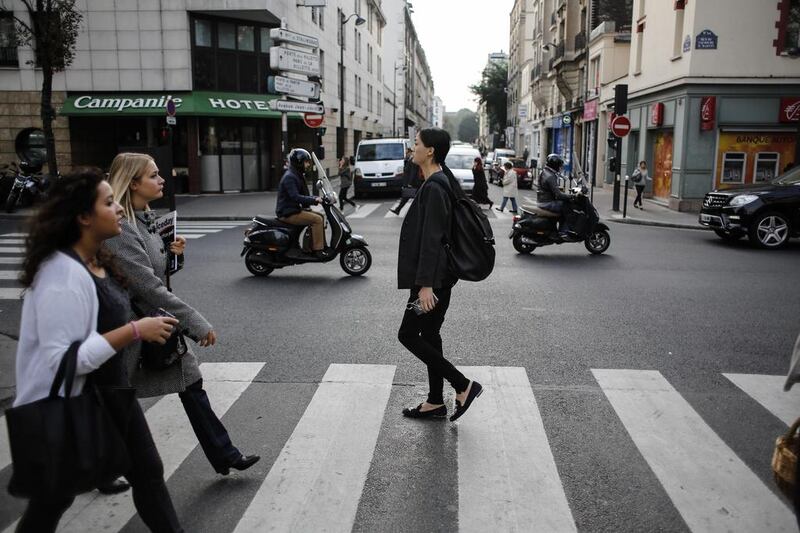 Qiwen Feng, centre, leaves her apartment as she starts her day. Yoan Valat / EPA