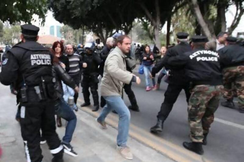 Employees of Laiki (Popular) Bank, the second largest on the island, clash with police as they demonstrate outside the House of Representatives in Nicosia.