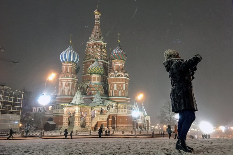 A woman takes pictures on Red Square in front of St Basil's Cathedral in Moscow. AFP